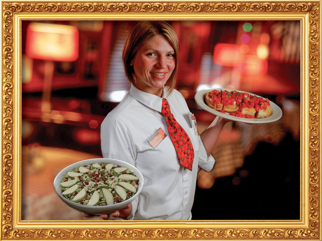 An employee holding food at Buca di Beppo