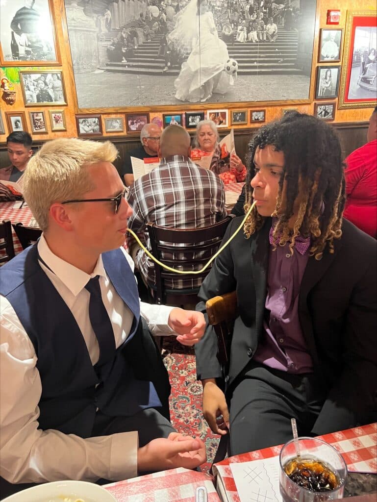 Two men in suits trying the pasta challenge